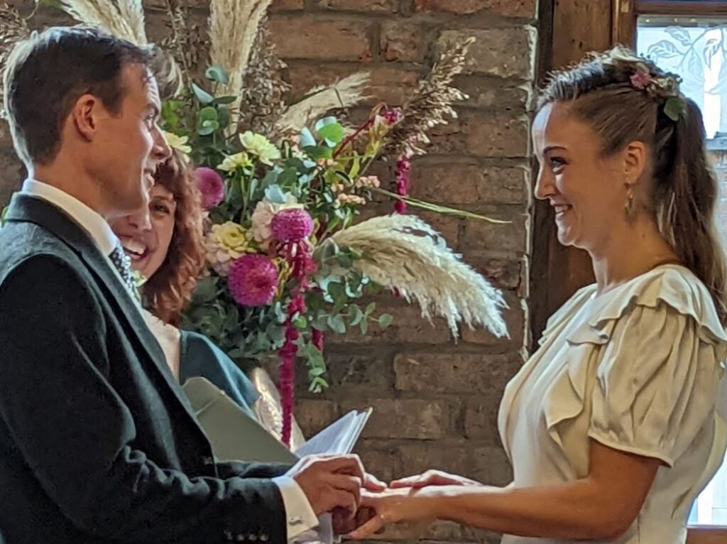 Amy Lee A couple smile at each other as they say their vows